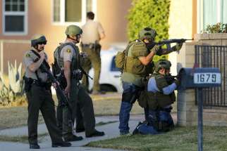Police officers conduct a manhunt after a mass shooting at the Inland Regional Center in San Bernardino, Calif., Dec. 2. At least 14 people were reported killed and more than a dozen injured when gunmen opened fire during a function at a center for people with developmental disabilities, police said.