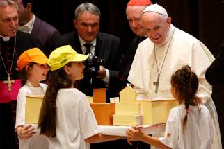  Pope Francis accepts a gift during an audience with children participating in the &quot;Train of Children&quot; at the Vatican June 9. Children from poor suburbs outside Milan arrived on a train that stopped at the Vatican. 