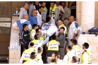 Israeli emergency personnel carry the body of a victim from the scene of an attack at a Jerusalem synagogue Nov. 18. 