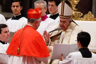 Pope Francis blesses new Cardinal John Dew of Wellington, New Zealand, after presenting the red biretta to him during a consistory at which the pope created 20 new cardinals in St. Peter&#039;s Basilica at the Vatican Feb. 14. 