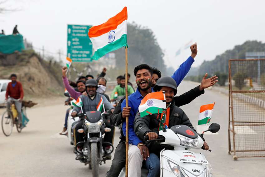 People ride motorbikes on the outskirts of Amritsar, India, March 1, 2019, before the arrival of an Indian air force pilot, who was captured by Pakistan two days earlier and later released. Catholic groups have joined the protest of military escalation in the region. 