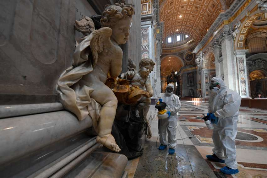 Vatican workers in protective gear sanitize various surfaces inside St. Peter&#039;s Basilica at the Vatican May 15, 2020, ahead of the resumption of Masses during the COVID-19 pandemic.