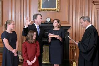 Judge Brett Kavanaugh, a Catholic, is sworn in as an associate justice of the U.S. Supreme Court by Chief Justice John Roberts, also a Catholic, as Kavanaugh&#039;s wife, Ashley holds the family Bible and his daughters, Liza and Margaret, look on Oct. 6.