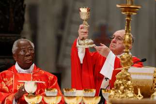 Pope Francis elevates the Eucharist as he celebrates Mass marking the feast of Pentecost in St. Peter&#039;s Basilica at the Vatican May 20. Alson pictured is Nigerian Cardinal Francis Arinze. The pope at his &quot;Regina Coeli&quot; announced that he will create 14 new cardinals June 29. 