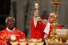 Pope Francis elevates the Eucharist as he celebrates Mass marking the feast of Pentecost in St. Peter&#039;s Basilica at the Vatican May 20. Alson pictured is Nigerian Cardinal Francis Arinze. The pope at his &quot;Regina Coeli&quot; announced that he will create 14 new cardinals June 29. 