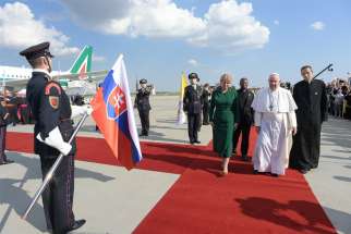 Pope Francis walks with Slovak President Zuzana Caputová as he arrives at the international airport in Bratislava, Slovakia, Sept. 12, 2021.