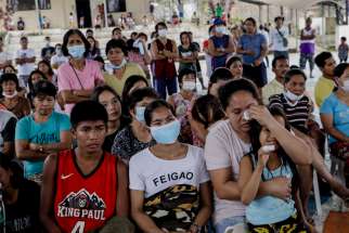 People displaced by the eruption of the Taal volcano attend Mass at an evacuation center in Tagaytay City, Philippines, Jan. 19, 2020. A Catholic priest has appealed for more and better shelters for victims of the volcanic eruption after criticizing a local government response.