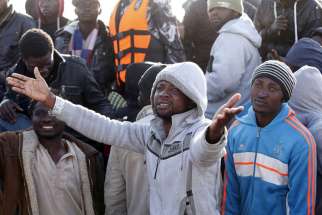 A migrant reacts after his boat was sent back by the Libyan navy to the coastal city of Misrata, Libya, May 3. More than 3,600 migrants were rescued at sea in 17 different operations in just one day in early May, according to the Italian coast guard.