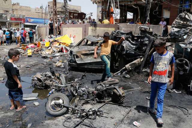 Boys look at the site of a car bomb attack in Baghdad, Iraq, Aug. 1. The Vatican called on Muslim leaders to condemn the &quot;barbarity&quot; and &quot;unspeakable criminal acts&quot; of Islamic State militants in Iraq.