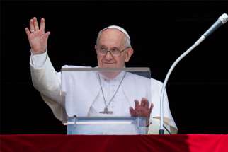Pope Francis waves as he leads the Angelus from the window of his studio overlooking St. Peter&#039;s Square at the Vatican.