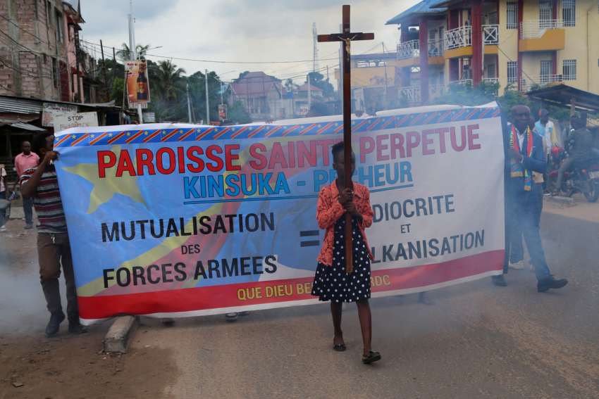A young woman carries a Cross during a march in Kinshasa, Democratic Republic of Congo, to protest escalating violence in the country Dec. 4.