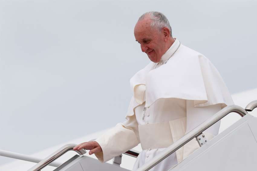 Pope Francis walks from the papal plane as he arrives at an airfield during a 2015 foreign trip.