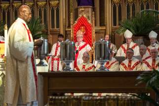 The chrism oil to be used for the next year in baptisms, confirmations and ordinations is brought to the altar during the annual Chrism Mass April 11 at St. Michael’s Cathedral.
