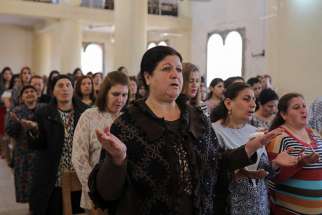 Worshippers pray during Easter Mass April 16 in St. George Chaldean Catholic church in Tel Esqof, Iraq. The church was damaged by Islamic State militants.