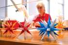An employee of the Herrnhut Star Co. in Hernnhut, Germany, creates the famous Christmas Moravian stars as visitors tour the workshop.