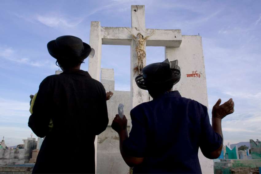 Women are pictured in a file photo praying on All Souls&#039; Day, Nov. 2, at a cemetery in Port-Au-Prince, Haiti.