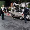A police officer and council worker clean the pavement Aug. 10 after overnight rioting and looting in Liverpool, England.