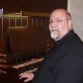 Fr. Shayne Craig sits next to the 30-year-old Casavant pipe organ installed in the chapel of Edmonton’s St. Joseph’s Seminary in January.
