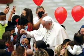 Pope Francis greets children during a meeting with youngsters assisted by the Vatican’s St. Martha pediatric clinic in the Paul VI hall at the Vatican Dec. 19. The Pope offered Christmas blessings and urged the children to listen to and help people in need.