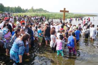 Pilgrims wade into Alberta&#039;s Lac Ste. Anne July 21, 2019. Thousands of pilgrims from across Canada gathered for the 130th annual Lac Ste. Anne Pilgrimage July 20-25.