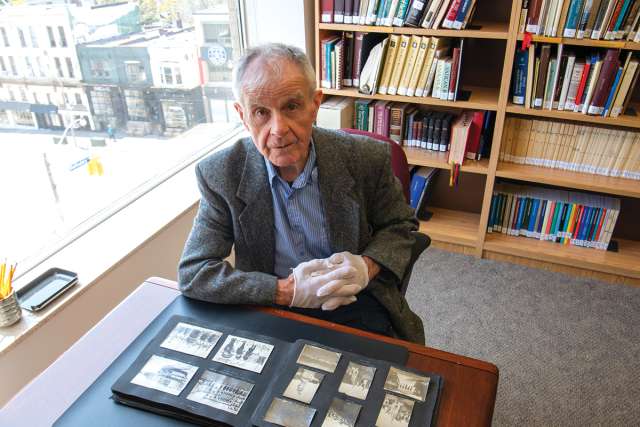 Freelance journalist Dan O’Reilly, above, with a photo album of pictures taken by Fr. Leo O’Reilly, right, a cousin of Dan’s father, at the Archives of the Roman Catholic Archdiocese of Toronto.