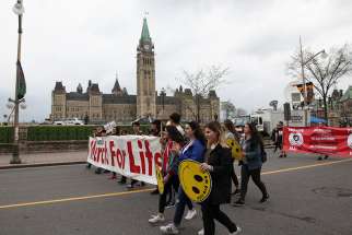 Young women carry a March for Life banner at Parliament Hill in Ottawa. Ontario passed bubble zone legislation last fall that forbids pro-life protesters inside a 50-meter zone around abortion clinics.