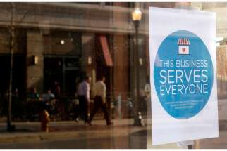 A sign reading, &quot;This business serves everyone,&quot; is seen in the window of a barbershop in downtown Lafayette, Ind., March 31. 