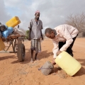 Adow Ibrahim Ali, right, provides water to Ibrahim Osman Mohammed in a remote section of eastern Kenya near the Somali border