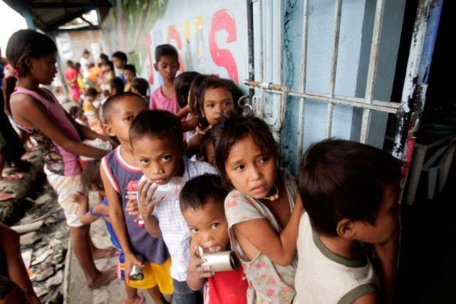 Children living in a squatters&#039; area wait for a free meal consisting of rice, chicken and vegetables that is given out daily near Manila, Philippines.