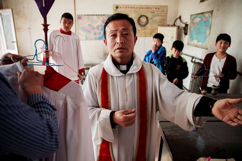 A priest gestures while vesting for Palm Sunday Mass March 25 at a Catholic church in Youtong, in China&#039;s Hebei province.