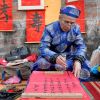 A calligrapher paints while waiting for customers on a street in Hanoi, Vietnam, Jan. 13. Calligraphy paintings are used for decoration during Tet, the Vietnamese lunar new year, which begins Jan. 23.