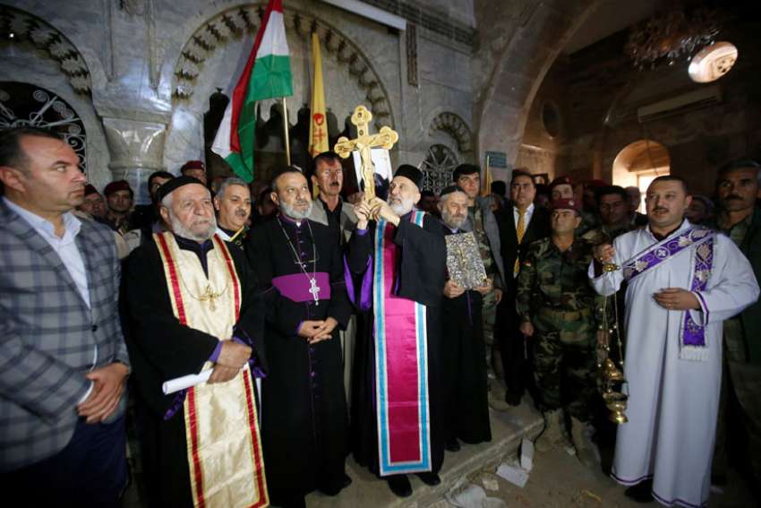 Iraqi Christians take part in a Nov. 19 procession to erect a new cross over a church, after the original cross was destroyed by Islamic State militants in the town of Bartella, Iraq, near Mosul.
