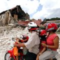 A family riding a motorcycle looks at a partially destroyed church in Bohol Oct. 17, two days after a magnitude 7.1 earthquake struck central Philippines. Many people throughout the region remained outdoors the night of Oct. 15 because they feared afters hocks.