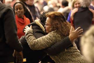 Women exchange the sign of peace during a solidarity Mass Jan. 31 at the Notre-Dame-de-Foy church in Quebec City for the six victims who were killed by a lone gunman Jan. 29 at the mosque belonging to the Quebec Islamic Cultural Center.
