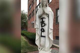 A statue of Mary defaced July 10, 2020, is seen on the grounds of Cathedral Prep School and Seminary in the Diocese of Brooklyn, N.Y. In the Los Angeles Archdiocese, Catholics said they are worried a July 11 fire that ravaged a historic mission church there and is still under investigation could be part of attacks on the Catholic Church, like the vandalization of statues.