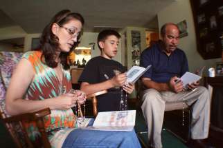 A family is pictured in a file photo praying the rosary in their Phoenix home. Catholic experts are expressing concern after a recent Pew Research Center survey found that only 35% of U.S. Catholic parents say that it is extremely or very important to them that their children grow up to hold similar religious beliefs.