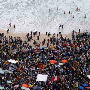 World Youth Day pilgrims await the arrival of Pope Francis on Copacabana beach in Rio de Janeiro July 25. Officials for World Youth Day announced that the beach will be the site of the World Youth Day vigil and closing Mass with Pope Francis, a change fr om the planned venue, which had been reduced to mud after three days of steady rain.