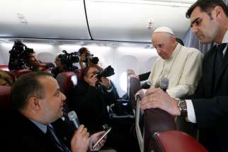 Pope Francis listens to a question from Romanian journalist Cristian Micaci aboard his flight from Sibiu, Romania, to Rome June 2, 2019.