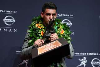Oregon Ducks quarterback Marcus Mariota kisses the Heisman Trophy during a Dec. 13 news conference at the New York Marriott Marquis after he was named the recipient of the trophy. Mariota is not Catholic but he regularly attends team Masses and graduated from an all-boys Catholic high school in Honolulu.