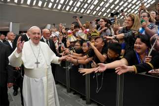 Pope Francis waves as he arrives for his general audience in Paul VI hall at the Vatican Aug. 7, 2019. Returning for the first audience following the summer break, the pope continued his series of talks on the Acts of Apostles and reflected on the words spoken by Peter and John before healing a disabled man asking for alms at the entrance to the temple.
