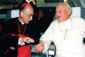 Pope John Paul II laughs while speaking with Italian Cardinal Camillo Ruini on board a papal flight in 1991.