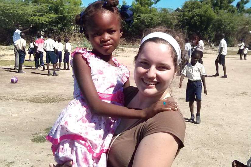 Caitlin Curtis in DeRac, Haiti with her sponsored child, seven-year-old Djanesca. The dress Djanesca is wearing was given to her by Caitlin.