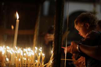 A child points at candles Dec. 19 in the Church of the Nativity, where tradition holds Christ was born, in Bethlehem, West Bank.