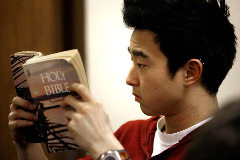  A young man is seen reading a Bible in 2010. A new State of the Bible Survey by the American Bible Society found that 77 percent of Catholics want to read the Bible more often.