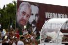 Pope Francis waves to people as he passes a billboard showing images of Cuba&#039;s former leader Fidel Castro and Cuban independence hero Jose Marti Sept. 19 in Havana.