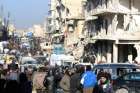 People wait near damaged buildings to be evacuated Dec.19 from Aleppo, Syria.