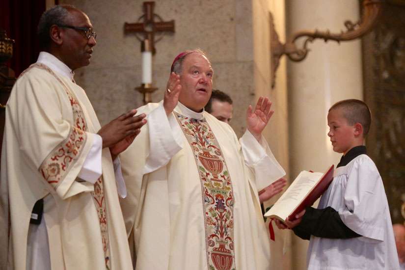 Deacon Phil Stewart looks on as Archbishop Bernard A. Hebda of St. Paul and Minneapolis reads a prayer during a July 8 Mass for peace and justice at the Cathedral of St. Paul. The Mass was offered in response to the July 6 shooting death of St. Paul, Minn., resident Philando Castile by a police officer.
