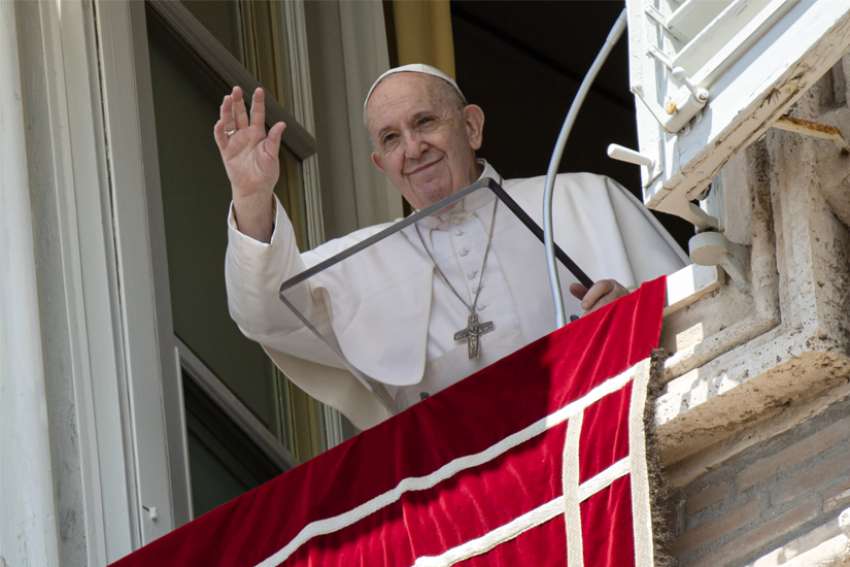 Pope Francis greets the crowd as he leads the Angelus from the window of his studio overlooking St. Peter&#039;s Square at the Vatican June 7, 2020. The pope urged people to not declare victory against COVID-19 but continue to be careful and follow health precautions.