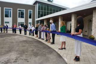 A long line of dignitaries lent a hand as Margaret Juravinski cut the ribbon to officially open Margaret’s Place Hospice.