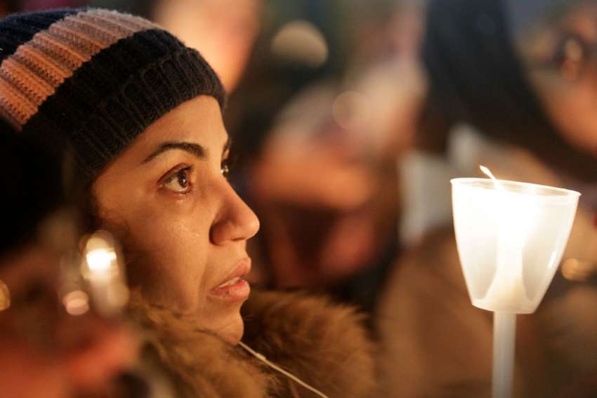 A woman becomes emotional during a Jan. 30 vigil in support of the Muslim community in Montreal. A lone gunman entered the Quebec Islamic Cultural Centre and opened fire Jan. 29, killing at least six men who were praying and injuring 19 more.